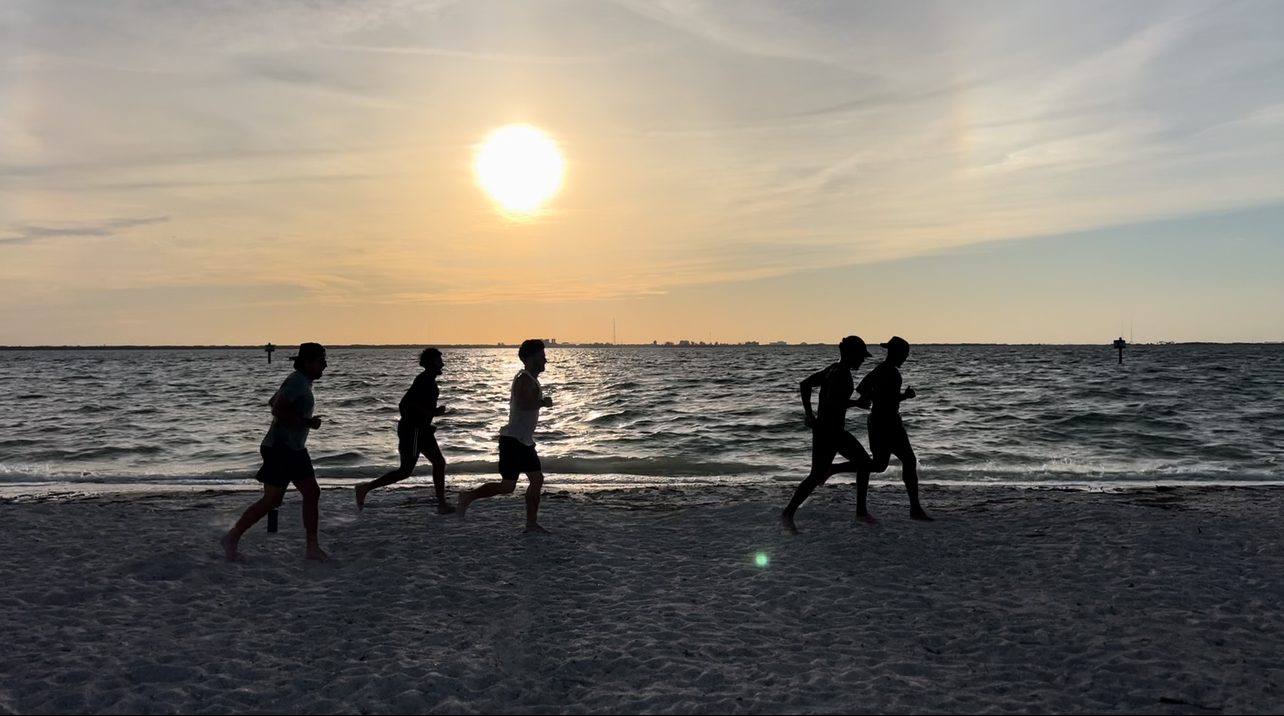 The brotherhood running together at sunrise on the beach in Tampa